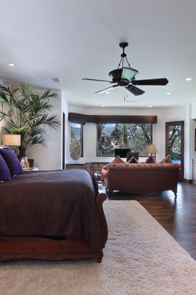 Спальная комната с большой кроватью с камином