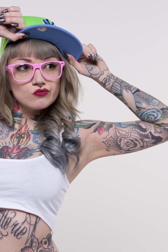 Девушка в кепке с татуировками по телу