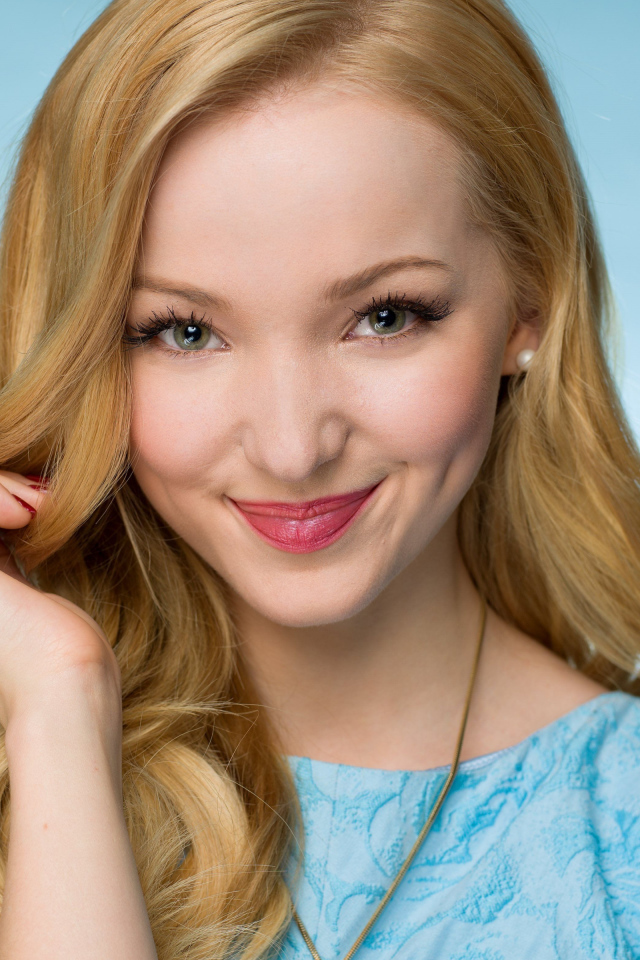 Улыбающаяся красивая девушка актриса Дав Кэмерон на голубом фоне