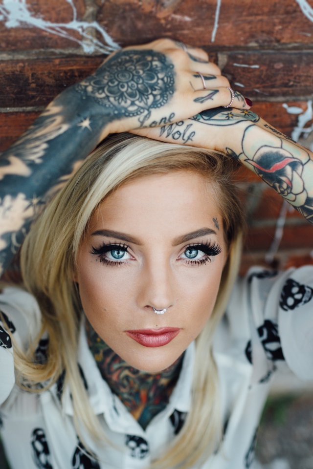 Young blond girl with tattoos on the body