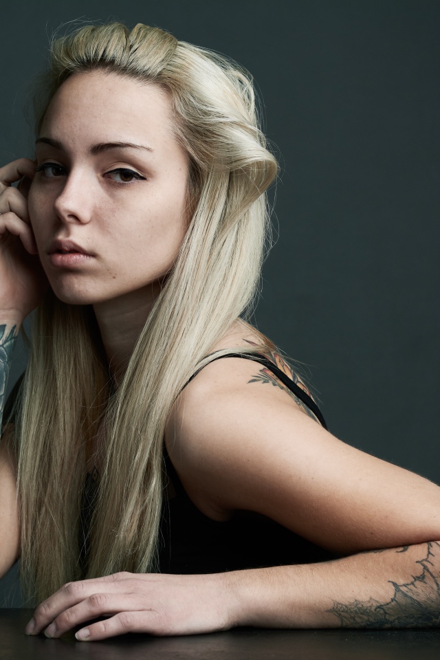 Молодая девушка с белыми волосами с татуировками на теле