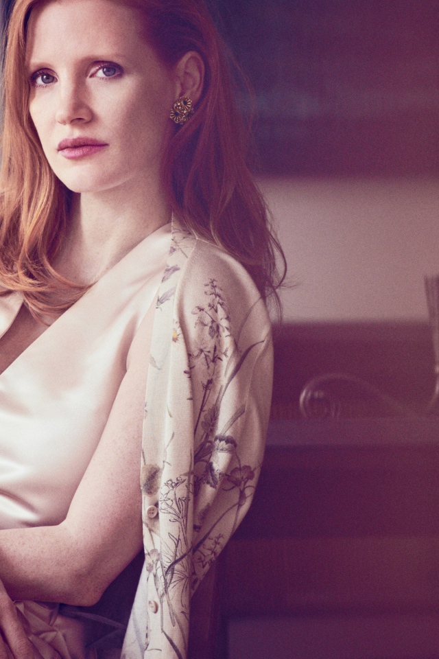 Молодая рыжеволосая актриса Джессика Честейн сидит на стуле