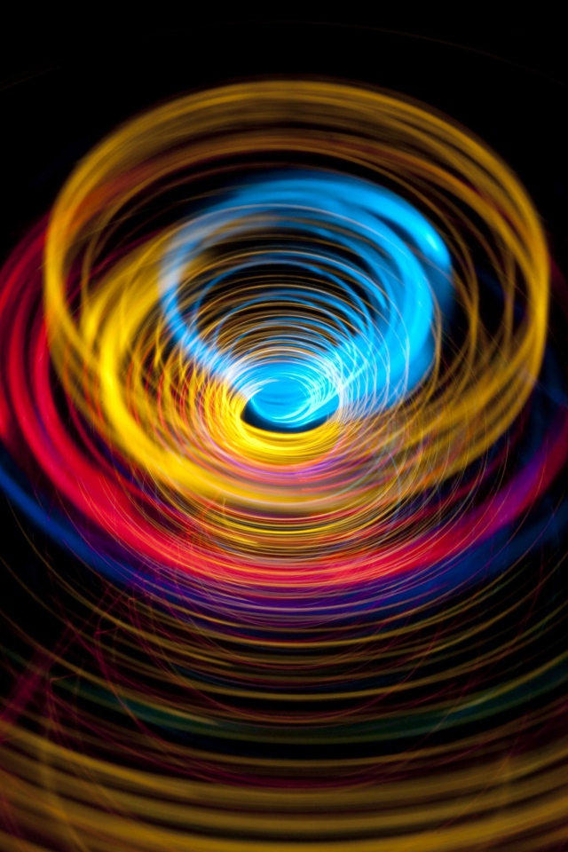 Разноцветные круги в воронке на черном фоне