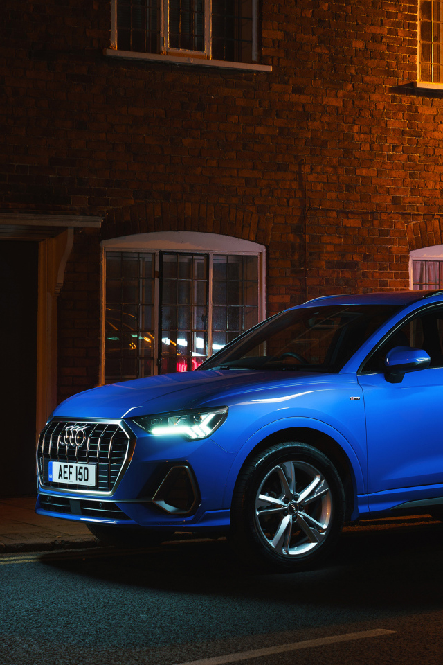 Синий автомобиль Audi Q3 35 TFSI S Line на фоне здания вечером