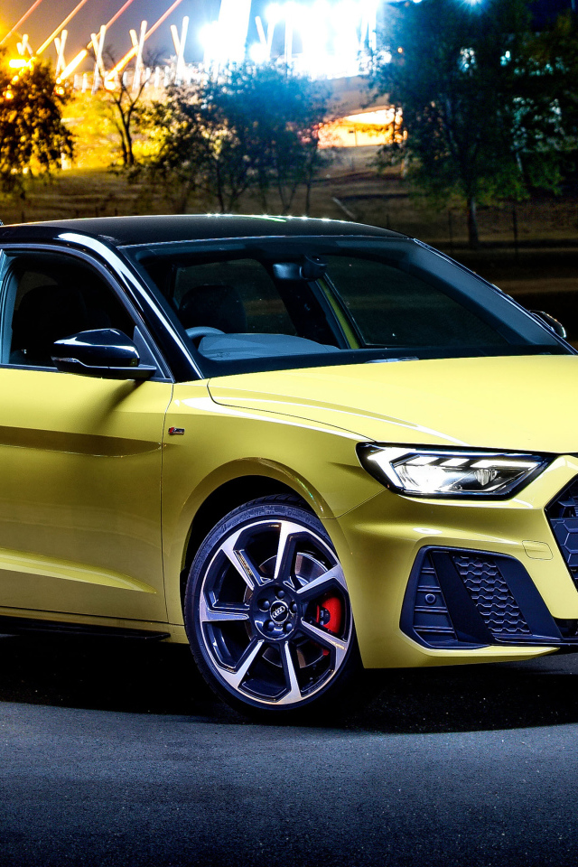 Желтый автомобиль Audi A1 Sportback 40 TFSI S Line Edition One 2019 года на фоне ночного города