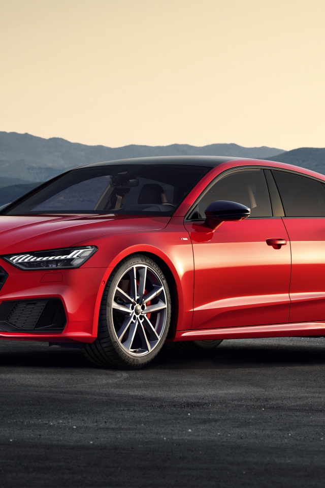Красный автомобиль Audi A7 Sportback 55 TFSI E Quattro S Line 2019 года в горах