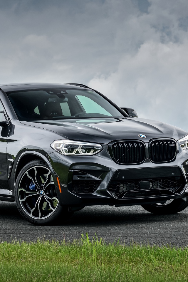 Черный автомобиль  BMW X4 M Competition, 2020 года на фоне грозового неба