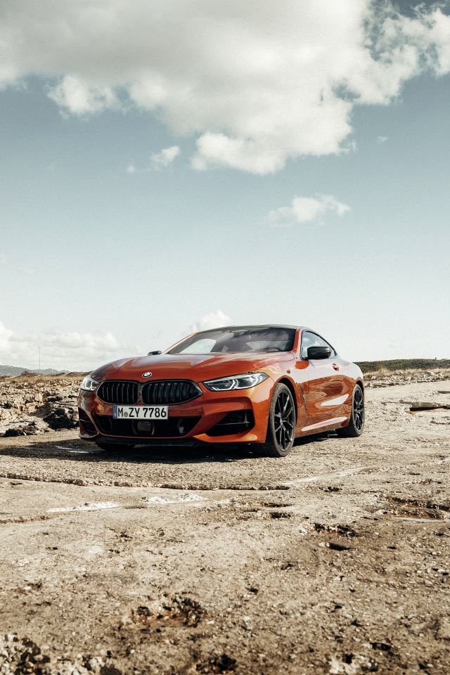 Красный автомобиль BMW 8 под голубым небом