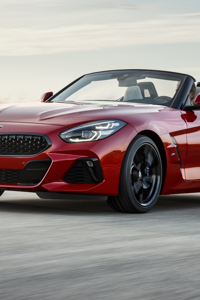 Красный автомобиль кабриолет BMW Z4 на дороге