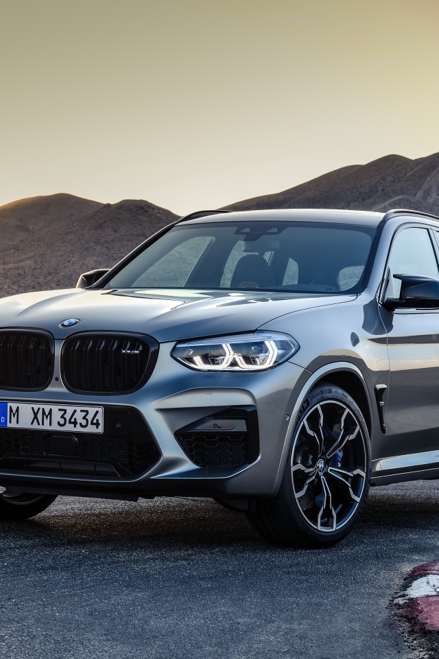 Серебристый автомобиль BMW X3  на асфальте