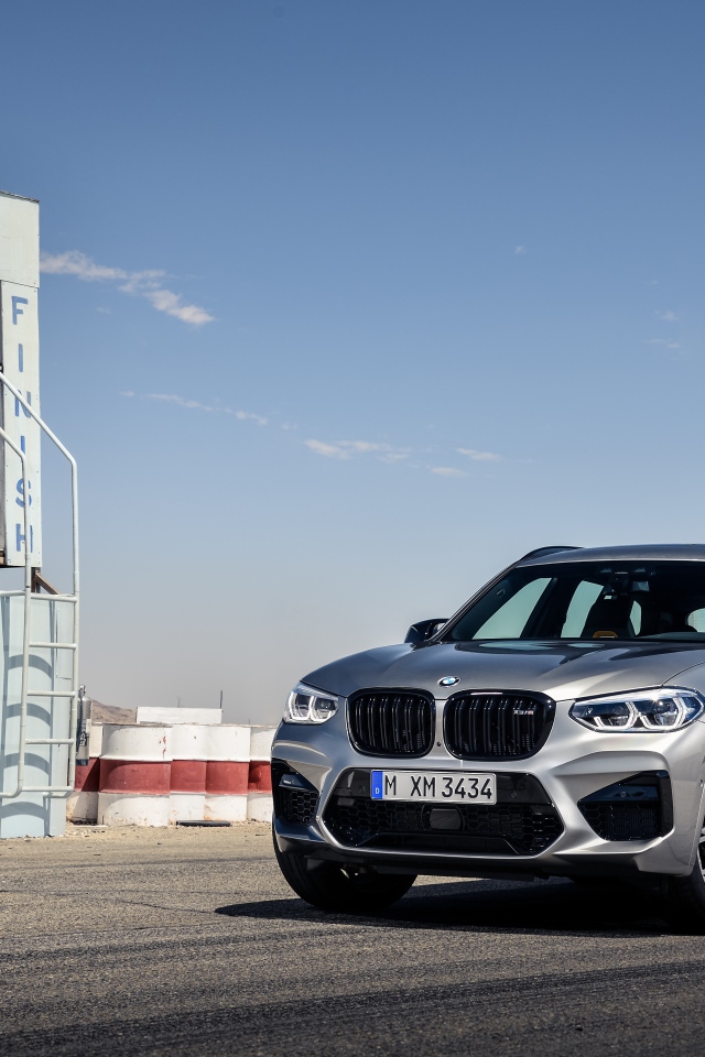Серебристый автомобиль BMW X3 на асфальте