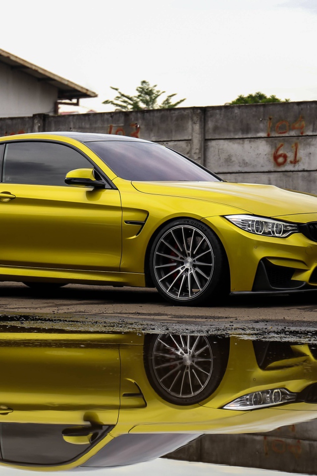 Желтый автомобиль BMW M5 отражается в воде 