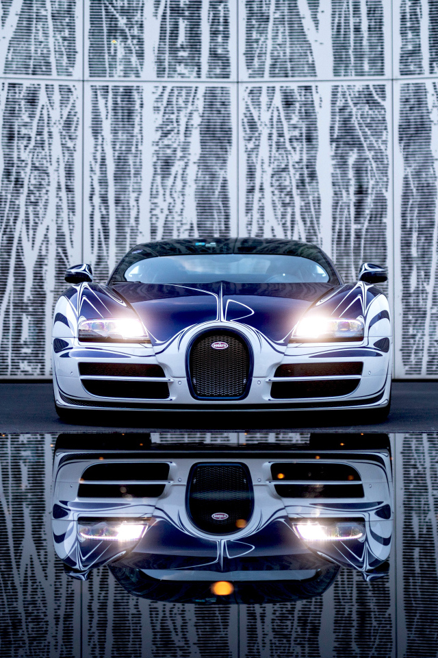 Автомобиль Bugatti Veyron Grand Sport Roadster отражается в зеркальной поверхности 