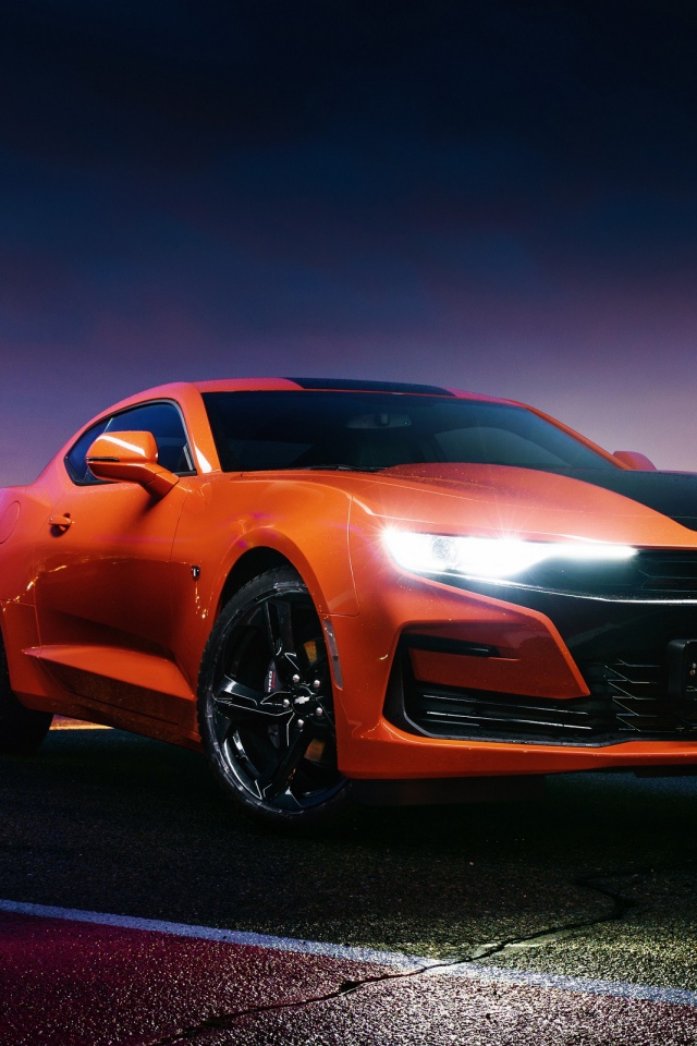 Оранжевый автомобиль Chevrolet Camaro, 2019 года с включенными фарами