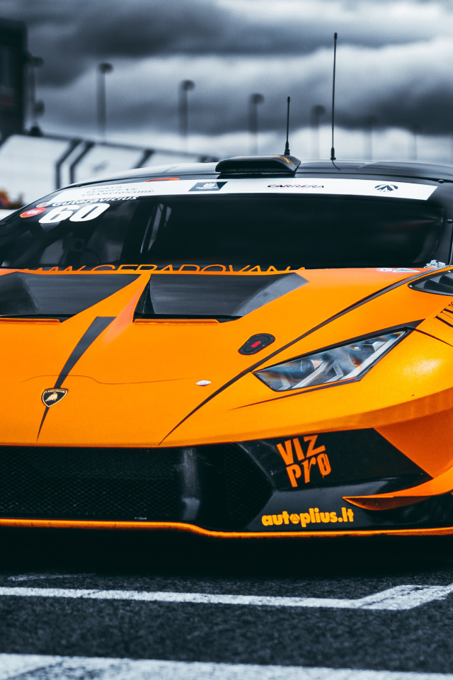 Оранжевый автомобиль Lamborghini Aventador на гонках