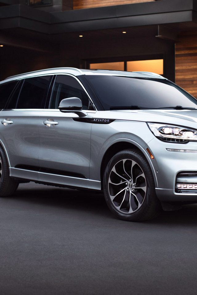 Серебристый внедорожник Lincoln Aviator Grand Touring, 2020 года на фоне дома