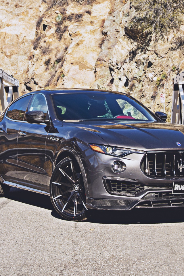 Внедорожник Maserati Levante на мосту на фоне гор