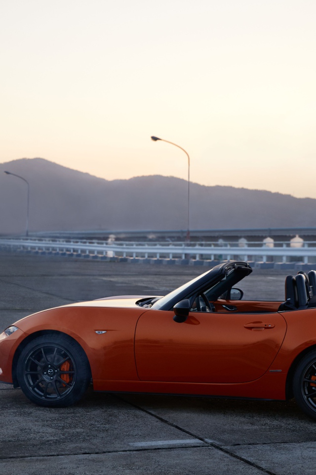 Оранжевый автомобиль кабриолет Mazda MX-5 на фоне неба