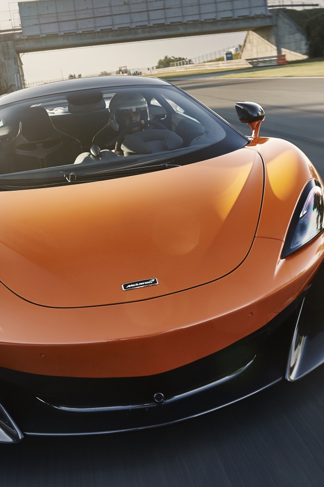 Спортивный оранжевый автомобиль McLaren 600LT 2019 года на трассе
