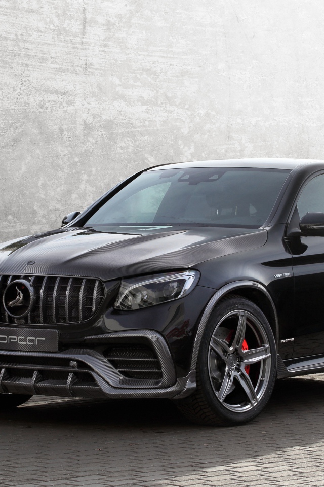 Black car Mercedes-AMG GLC 63 on the background of a gray wall