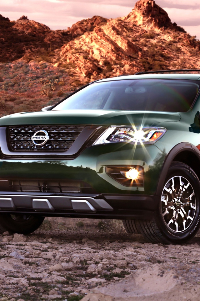 Зеленый автомобиль Nissan Pathfinder в горах 