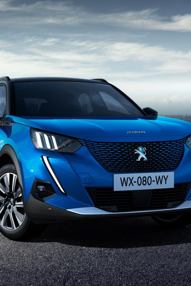 Синий внедорожник Peugeot E-2008 GT, 2019 года на фоне небоскребов