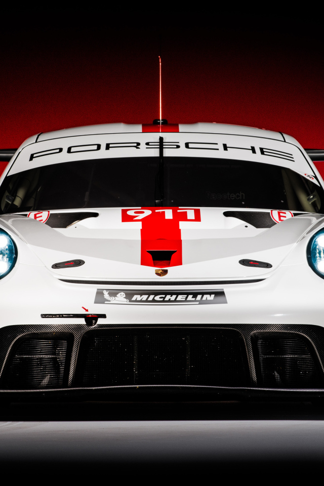 Спортивный автомобиль Porsche 911 RSR 2019 года на красном фоне