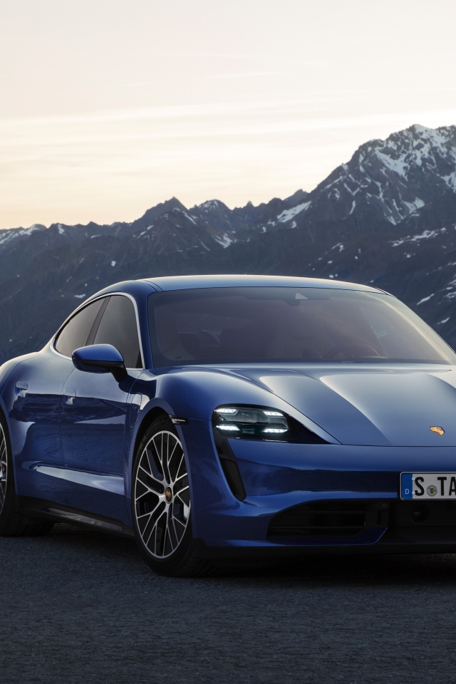 Синий стильный автомобиль Porsche Taycan Turbo 2019 года на фоне гор