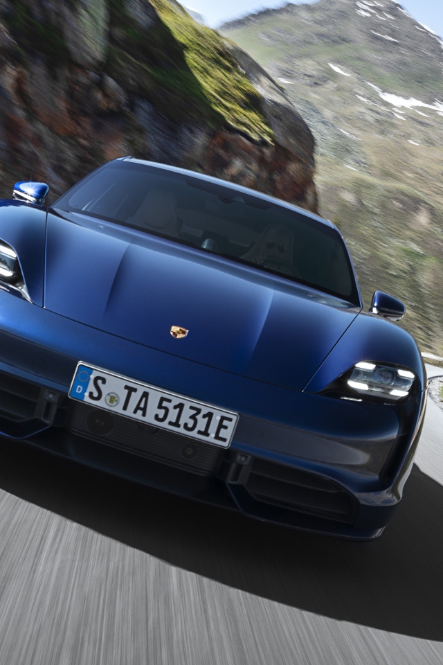 Синий автомобиль Porsche Taycan Turbo 2019 года на фоне гор