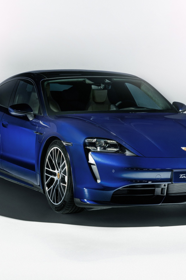Синий автомобиль Porsche Taycan Turbo 2019 года на сером фоне