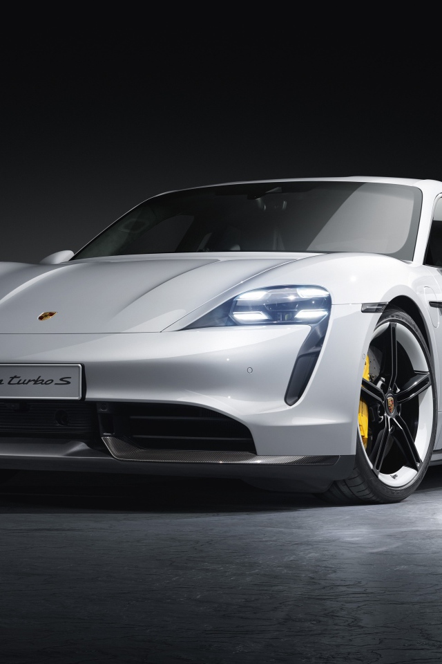 Серебристый автомобиль Porsche Taycan Turbo S 2019 года на сером фоне