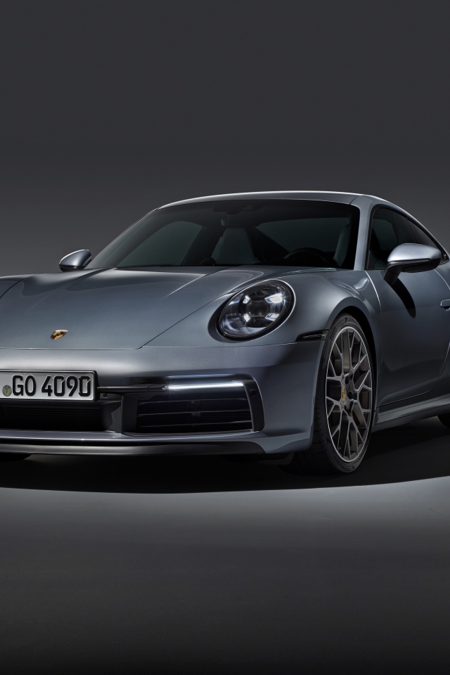 Серебристый автомобиль Porsche 911 Carrera 4S на сером фоне