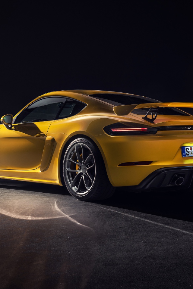 Желтый автомобиль Porsche 718 Cayman GT4, 2019 года вид сзади