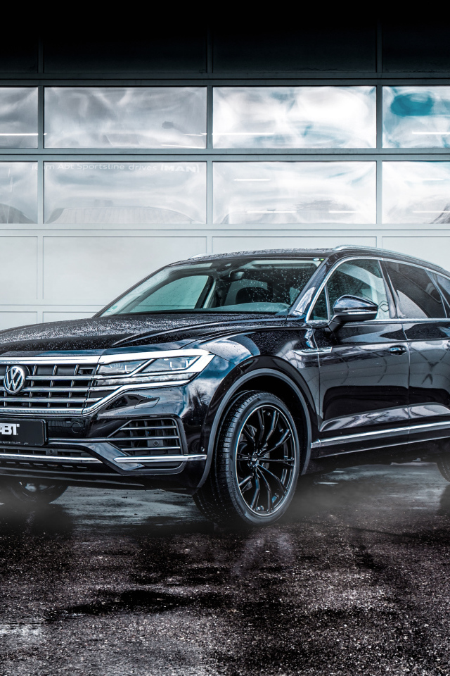 Черный автомобиль Volkswagen Touareg 2018 года у гаража