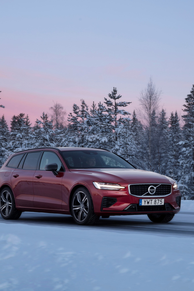 Красный автомобиль Volvo V60 на зимней дороге