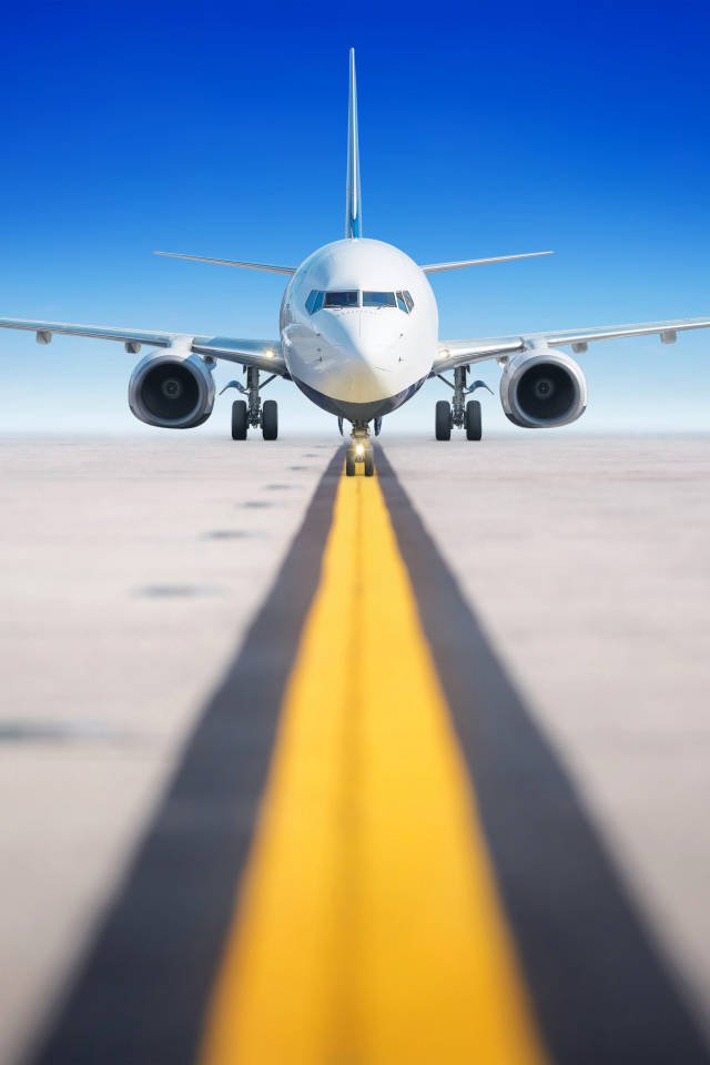 Большой пассажирский самолет на взлетной полосе на фоне голубого неба