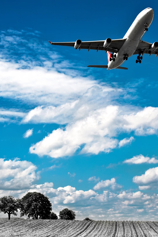 Самолет авиакомпании Swiss Airlines в небе с белыми облаками