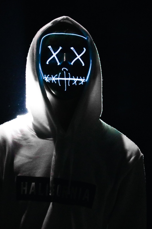 Светящаяся маска на лице у парня в худи
