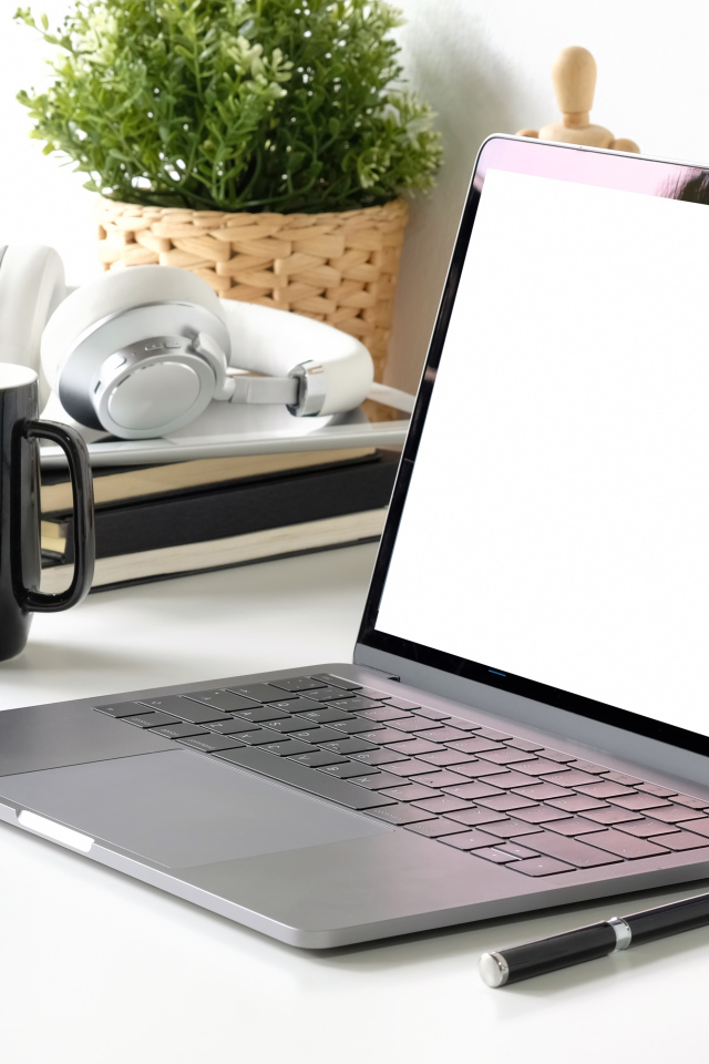 Ноутбук на рабочем столе с чашкой 