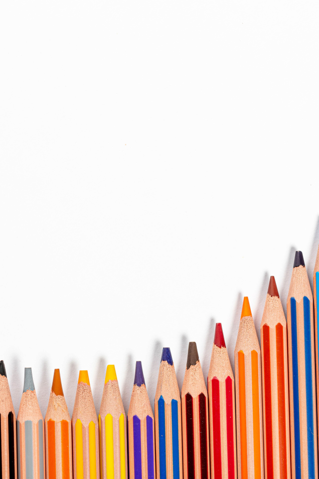 Много разноцветных карандашей на белом фоне