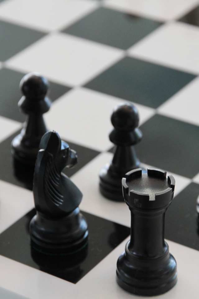 Черные шахматные фигуры на доске