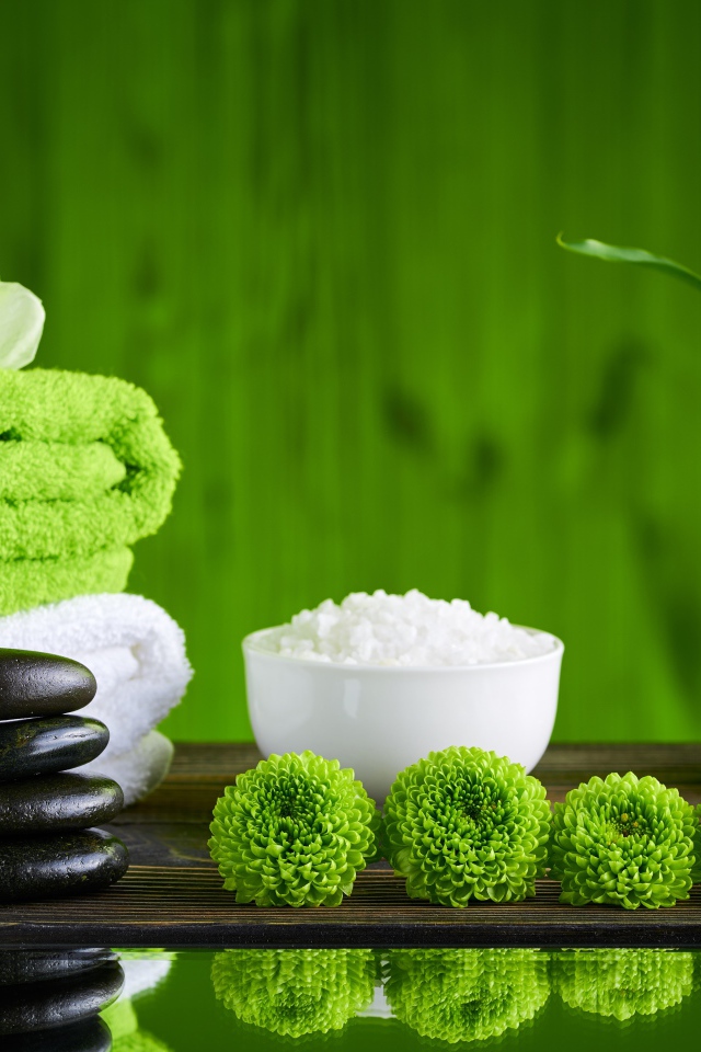 Черные камни, полотенца, соль и цветы у воды для SPA