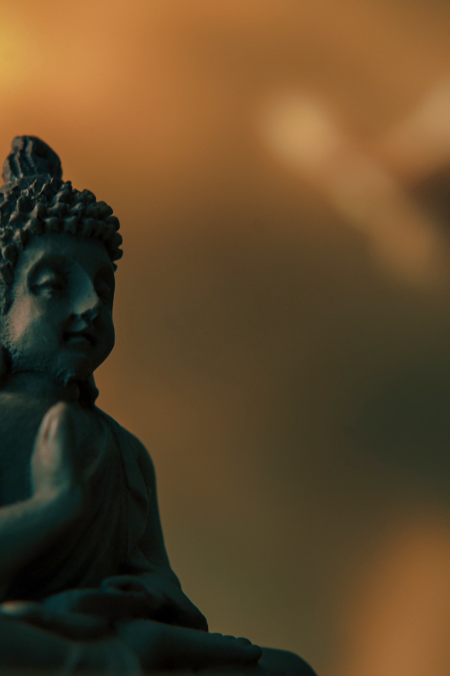 Статуэтка Будда на коричневом фоне крупным планом