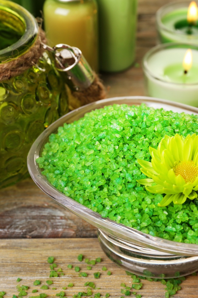 Зеленая ароматная морская соль на столе с зажженными свечами