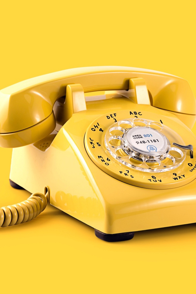 Старый желтый телефон на желтом фоне