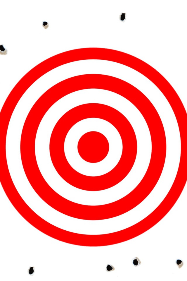 Красная мишень на белом фоне с дырками от пуль