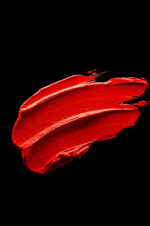 Мазок красной краски на черном фоне