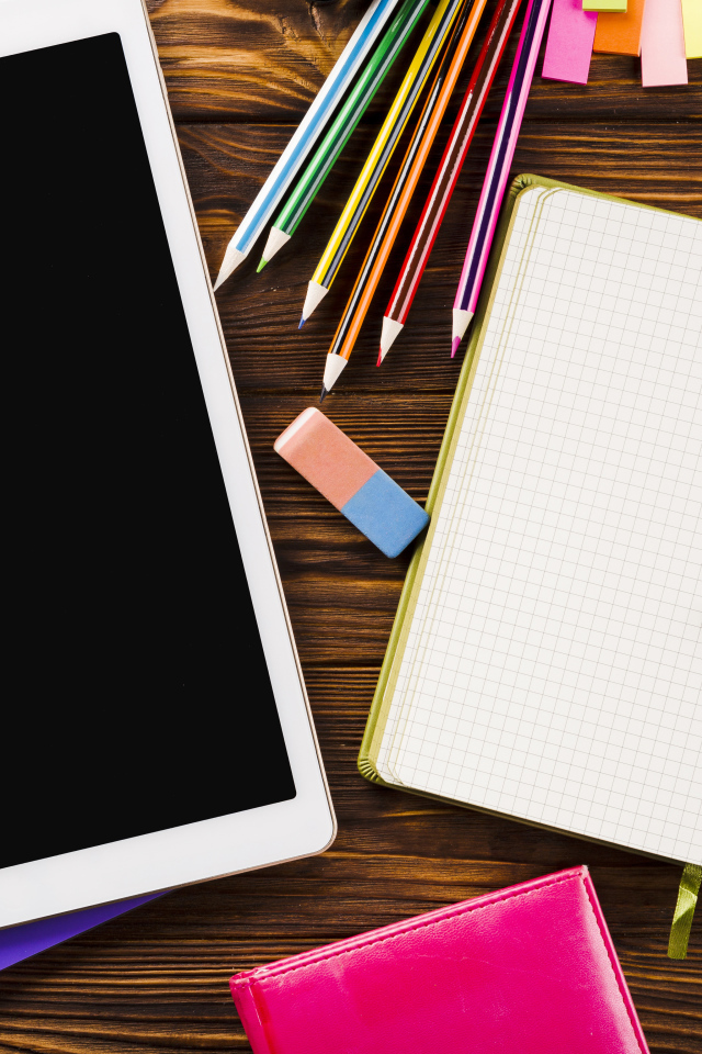 Планшет на столе с блокнотом и карандашами