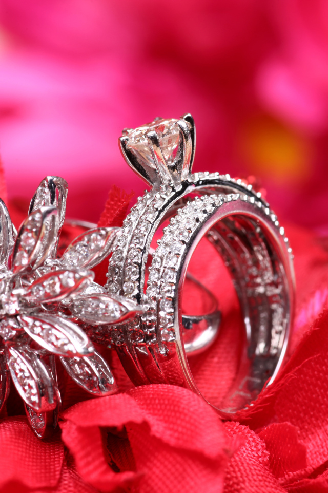 Два кольца с камнями лежат на цветке 