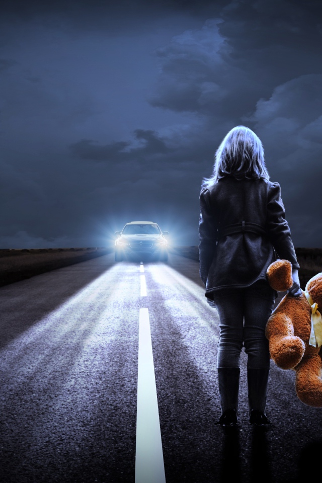 Девушка стоит на дороге с игрушечным медведем